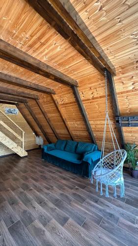 a porch with a swing in a wooden ceiling at Cabana Arunia in Buninginea