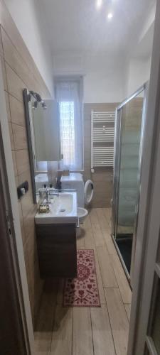 a bathroom with a sink and a toilet and a mirror at Charlie's House in Venaria Reale