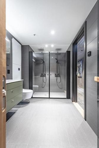 a bathroom with a walk in shower and a toilet at Ski out ski in Luxus Hemsedal in Hemsedal