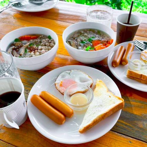 a table with plates of food and bowls of soup at Dewy Hill ดิวอี้ ฮิลล์ เขาใหญ่ วังน้ำเขียว in Ban Khlong Krathon