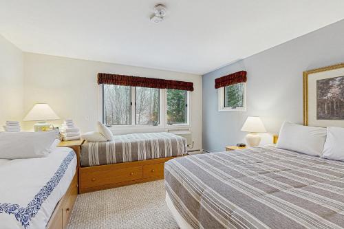 a bedroom with two beds and two windows at Trailside Highlands #8 in Jeffersonville