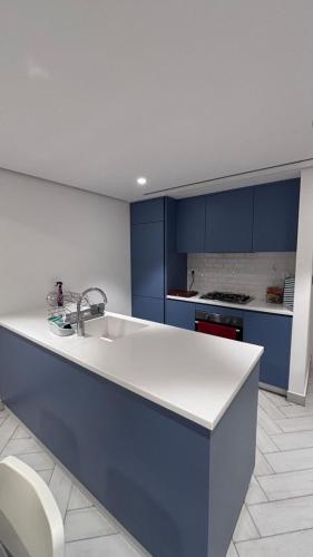 a kitchen with blue cabinets and a white sink at العقبة in Aqaba