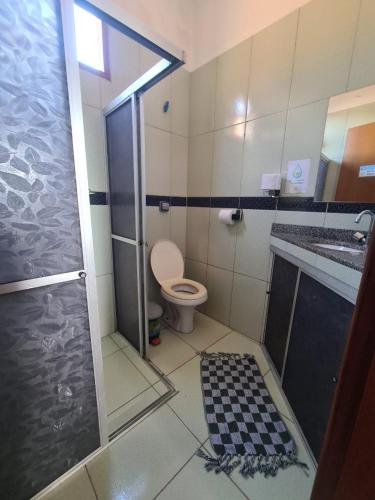 a bathroom with a shower and a toilet and a sink at Casa Temporada Lençóis in Lençóis