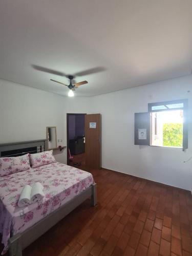 a bedroom with a bed and a ceiling fan at Casa Temporada Lençóis in Lençóis