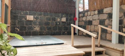 a mattress on a porch with a brick wall at Love & Lemons in Yesod Hamaala