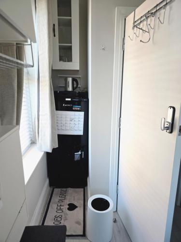 a small kitchen with a black washer and dryer at Snug in London