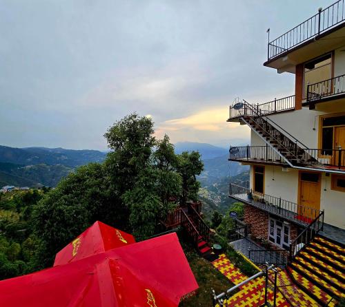 a red umbrella sitting next to a building at Hotel HiLL Mount View Dalhousie Chamba in Dalhousie