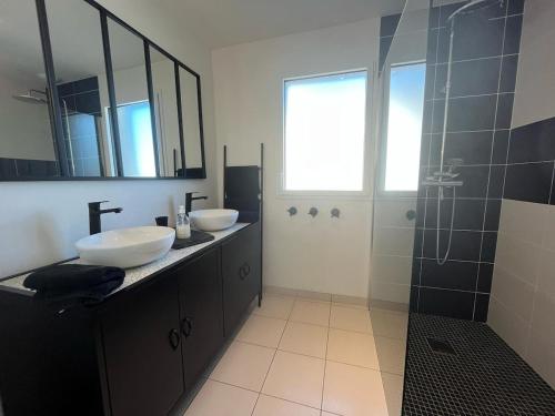 a bathroom with two sinks and a shower at Cap Coz Cottage 4* a 500 m de la plage de sable fin in Fouesnant