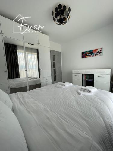 a white bedroom with a large white bed in it at Modern City View Apartment by Evan Apartments in Şelimbăr