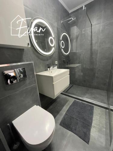 a bathroom with a toilet and a sink and a shower at Modern City View Apartment by Evan Apartments in Şelimbăr
