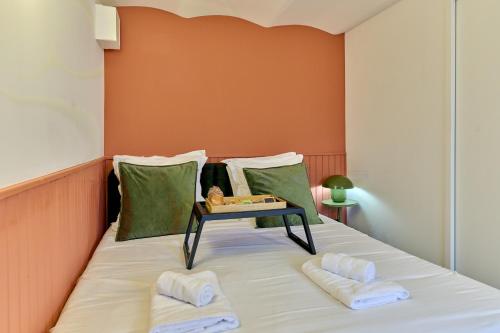 a bed with two pillows and a table on it at Le Petit Cocon, Hotel Style Ideal for Professionals or Couples in Nevers