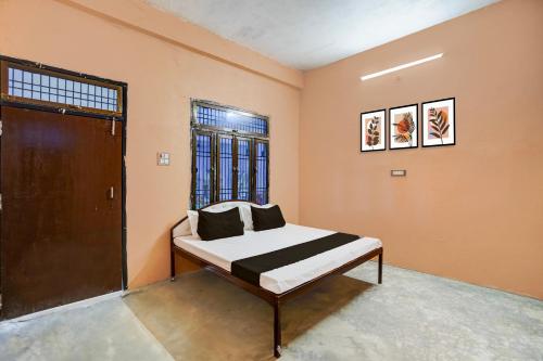 a bedroom with a bed in a room with orange walls at Hotel O Guru in Jhūsi