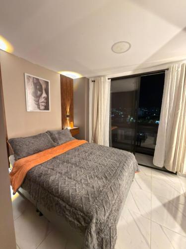 a bedroom with a bed and a large window at Moderno apt con vista a la ciudad y estilo único in Pereira