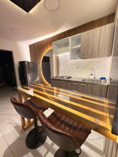 a kitchen with a table and some chairs and a sink at Moderno apt con vista a la ciudad y estilo único in Pereira