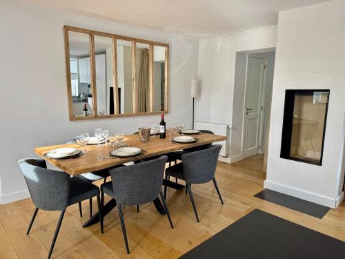 a dining room with a wooden table and chairs at Maison privative dans un environnement idyllique in Lasne