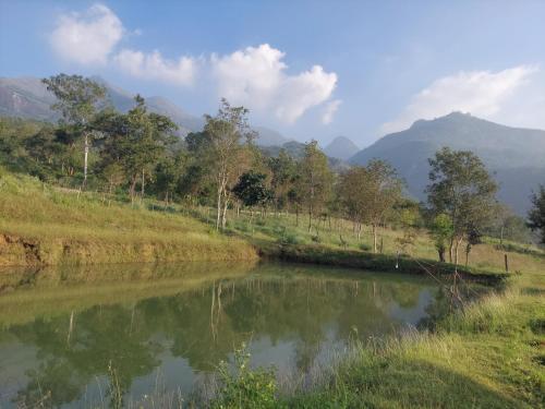 a river with trees and mountains in the background at Haven heights in Kanthalloor