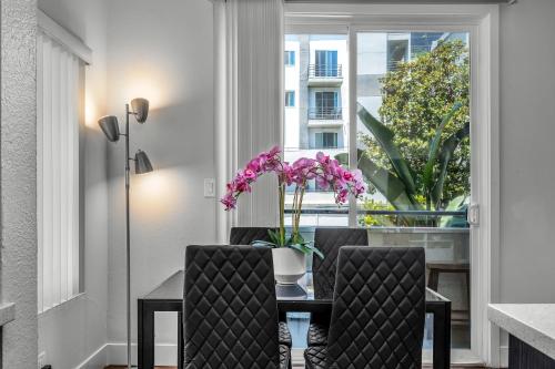 a dining room with a table and chairs and a window at Heart of La, Walk to everything!! in Los Angeles
