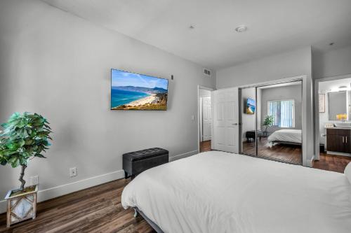 a bedroom with a white bed and a painting on the wall at Heart of La, Walk to everything!! in Los Angeles