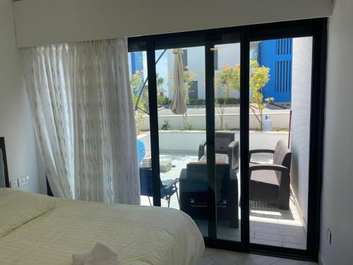 a bedroom with a bed and a view of a patio at ازور in Aqaba
