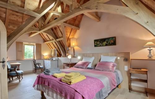a bedroom with a large bed with pink sheets at Propriété De Campagne Typique in Brasparts