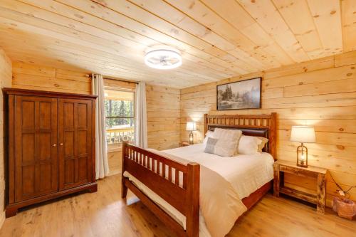 a bedroom with a bed in a log cabin at Hike, Ski and Explore Bigfork Cabin with Mtn Views! in Finley Point