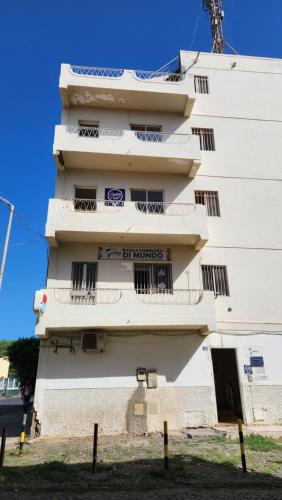 a white building with balconies on the side of it at Meeting Point Praia-QC Beachwalk, also in Tarrafal & Fogo-NO CASH ACCEPTED in Praia