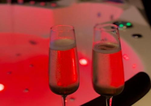 two glasses of wine sitting on top of a table at Love room 10 minutes de Nantes in Thouaré-sur-Loire