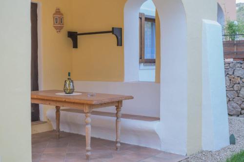 a table with a bottle on it next to a wall at Beautiful Giardino Degli Oleandri-1BedApt BILO4 in Liscia di Vacca