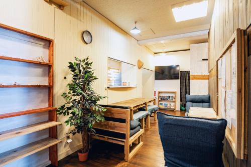 a room with a table and chairs and a clock at 全室個室 Private Stay Guesthouse Opuntia in Ishigaki Island