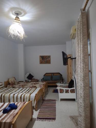 a bedroom with three beds and a chandelier at Dar Aziz VIP in Sousse