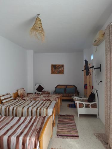a room with two beds and a table in it at Dar Aziz VIP in Sousse