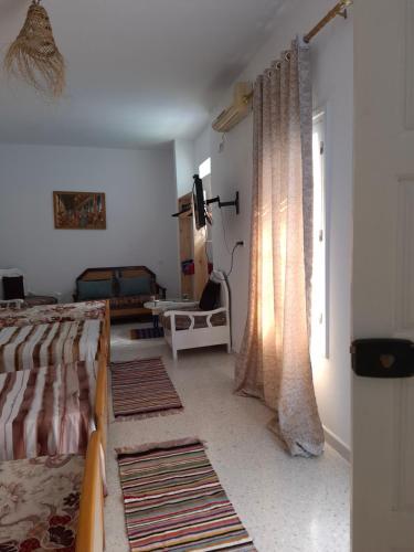 a bedroom with a bed and a window with curtains at Dar Aziz VIP in Sousse