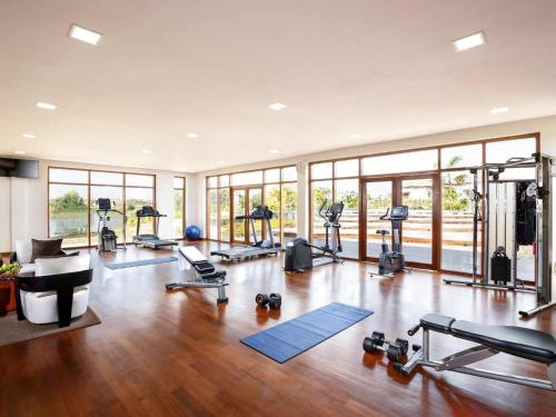 a gym with several treadmills and machines in a room at The Lake Garden Hotel Nay Pyi Taw - MGallery Collection in Nay Pyi Taw