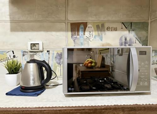 a microwave oven on a counter with a tea kettle at 2 Bedroom Modern Flat at Zayed Compound in Sheikh Zayed