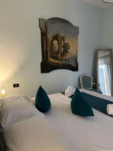 a white bed with green pillows in a bedroom at Luxury Suite Vitruvio 55 in Formia