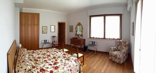 een slaapkamer met een bed, een stoel en een raam bij IlPoggetto Bed&Breakfast in Civitanova Marche