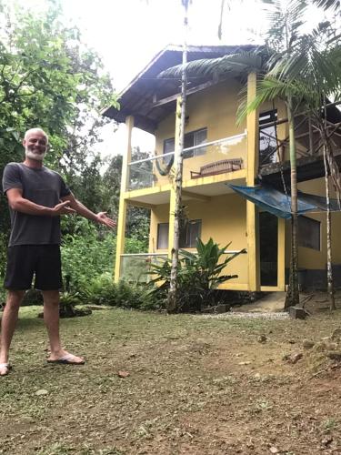 a man standing in front of a house at Flat Boa Vista in Paraty