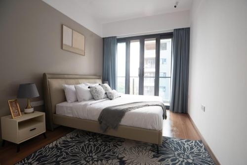 a bedroom with a bed and a large window at Magnolia Lux - Luxury apt, ocean view, gym, pool in Dar es Salaam