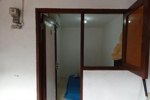 a bathroom with a mirror and a door to a room at Kost 48 Surabaya in Surabaya