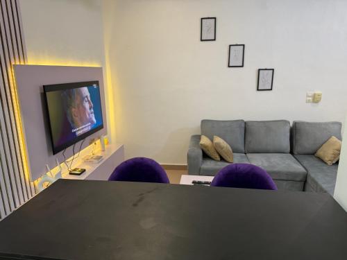 a living room with a table and purple chairs at Appartement 2 pièces in Agonkamè