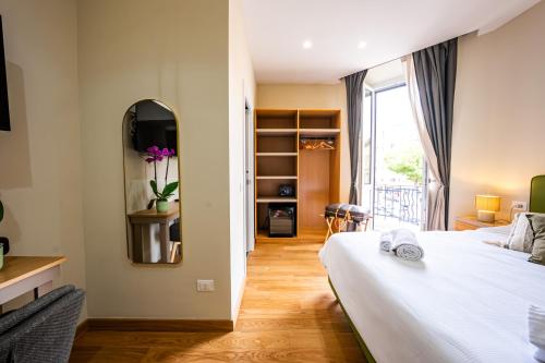 a bedroom with a white bed and a mirror at MAMA Relais in Rome