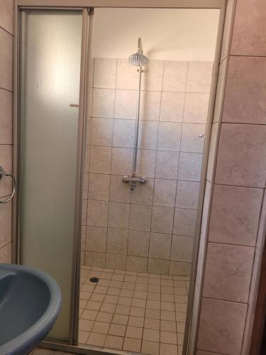 a shower with a glass door in a bathroom at Guestmate Inn in Livingstone
