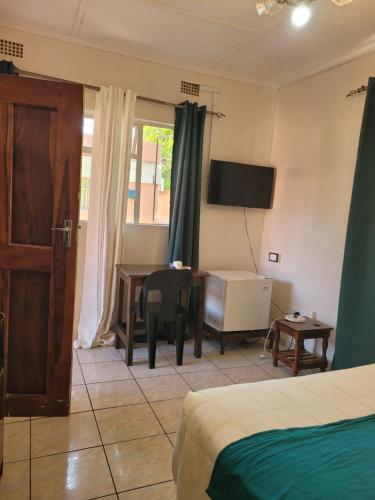 a bedroom with a bed and a desk and a table at Guestmate Inn in Livingstone
