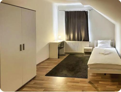 een witte slaapkamer met een bed en een raam bij Adelin Vienna in Wenen