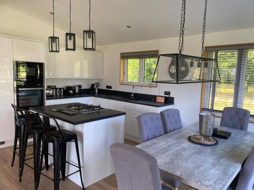 a kitchen with a table and chairs in a kitchen at Contemporary 3 bed luxury Spa lodge with hot tub in Bury Saint Edmunds