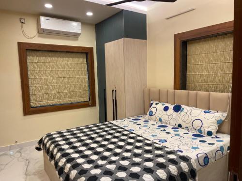 kolkataにあるJN 2BHK Studio Apartment Biratiのベッドルーム1室(ベッド1台、白黒の掛け布団付)
