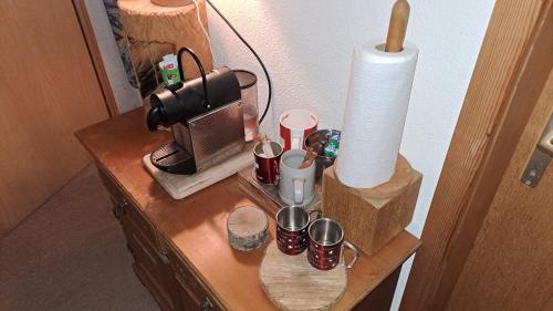 a table with a coffee maker and cups on it at Chalet Chnorz Hosted in Nesslau