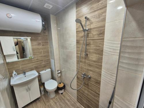 a bathroom with a shower and a toilet and a sink at Apartment The Garden in Ruse