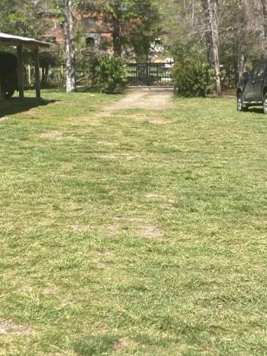 a field of grass with a car parked in it at Los arrayanes de huife pucon in Termas De Huife