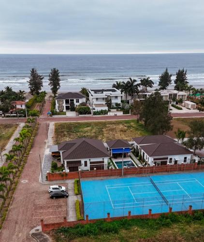 an aerial view of a resort with a tennis court and the ocean at Casa Grace Olón in Olón